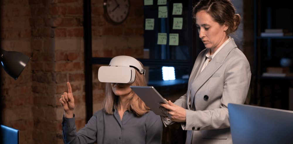 Two professionals in an office setting, one wearing a VR headset and the other holding a tablet, demonstrating gamified recruitment.